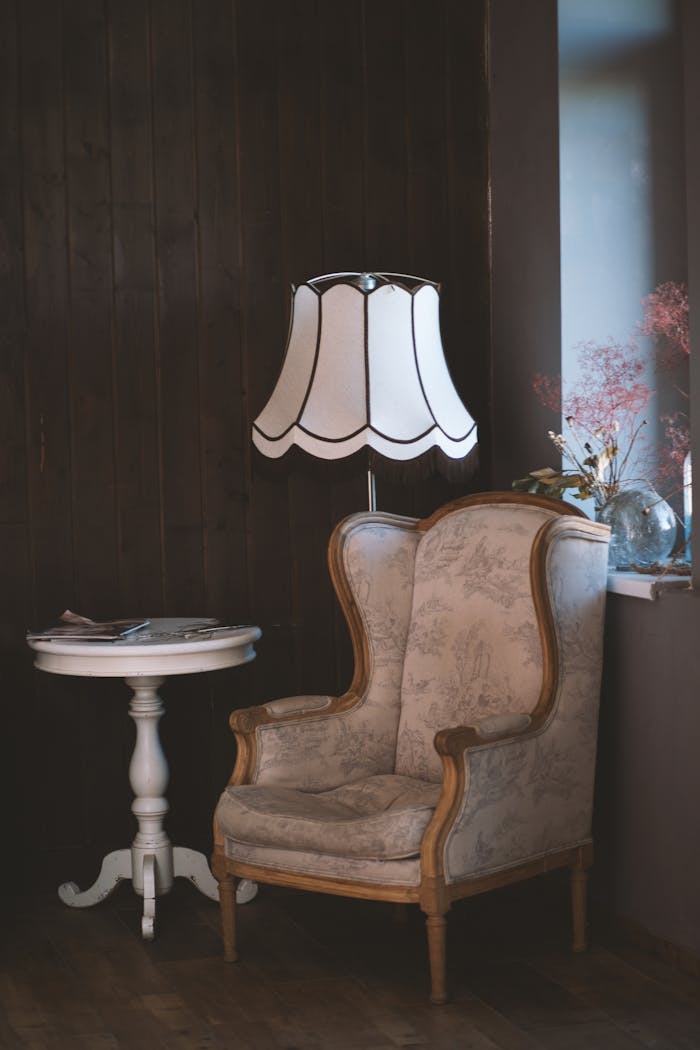 Charming vintage interior with an armchair, elegant lamp, and side table. Perfect for cozy settings.